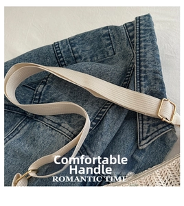 Detailed close-up of dark denim fabric with beige woven strap and golden metal buckle