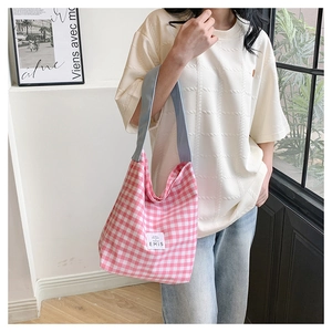 Detailed shot of pink gingham canvas tote bag with EMIS logo and blue shoulder straps