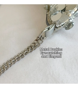 Detail of silver metal chain and clasp on sequined bag with elegant textured finish