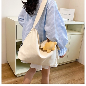 Detail of white canvas tote bag with fashion tag and yellow star plush charm