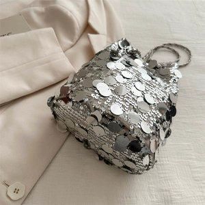 Chic silver sequin bucket bag with metal chain strap on a stylish blazer background