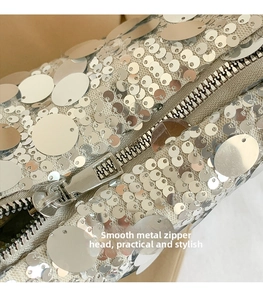 Detail of silver sequins and smooth metal zipper slider on a stylish shoulder bag