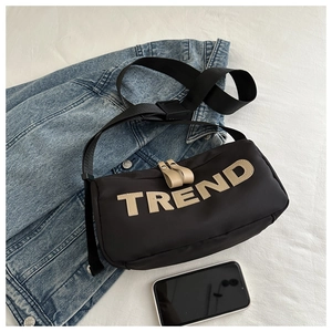 Detail of black oxford crossbody bag with TREND letter patch and adjustable strap