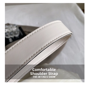 Detail of a minimalist off-white leather shoulder strap with precise reinforced stitching