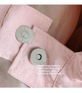 Macro shot of silver magnetic buckle on pink fabric bag with herringbone lining
