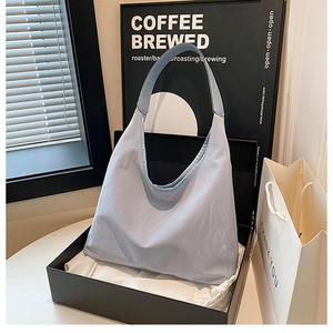 Close-up of light blue nylon tote bag with wavy rim in a minimalist urban setting