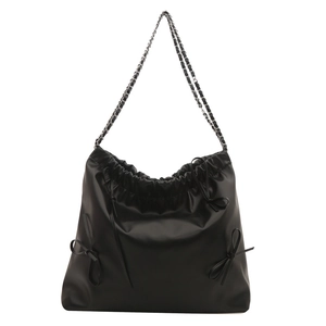 Chic black soft leather shoulder bag with decorative bows and silver chain straps