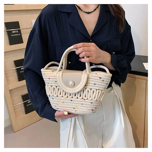 Detail of hand-woven off-white tote bag featuring colorful dots and a large pearl button