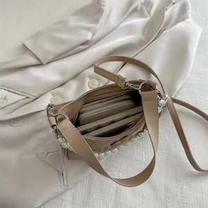 Chic pearl handle shoulder bag in cream PU leather showing spacious interior compartment