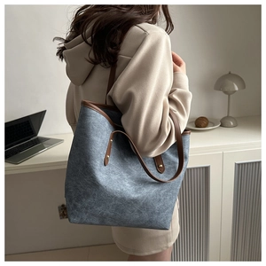 Dettaglio della grande borsa tote vintage grigio-blu con manici marroni e borchie