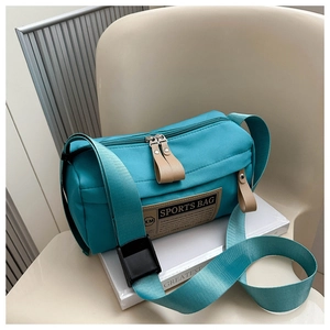 Detail of teal sports bag showing durable nylon fabric and branded vintage label