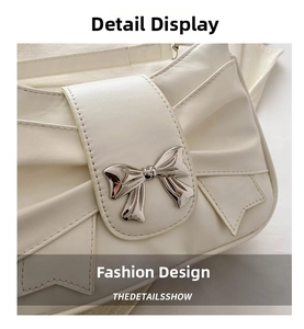 Detailed close-up of cream bow-shaped handbag featuring a metallic butterfly clasp
