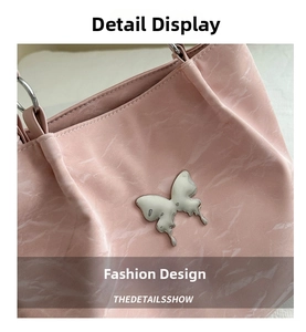Détail de la boucle papillon en métal liquide et texture marbre de ce sac cabas rose