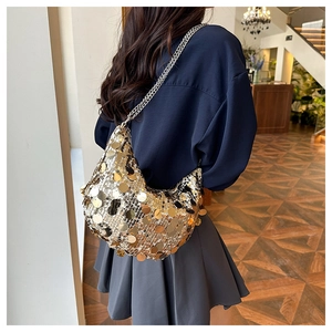 Close-up of golden sequin hobo bag with dual silver chain straps on a model