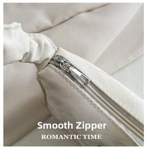 Detail view of smooth silver zipper and soft cream pleated texture on square shoulder bag