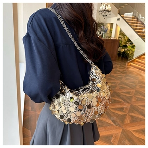 Chic crescent bag with gold sequins and silver double chains shown on a model's shoulder
