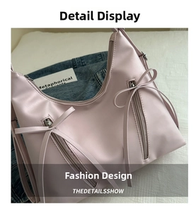 Detail view of pink bucket bag featuring decorative double zip pockets with long bow ties