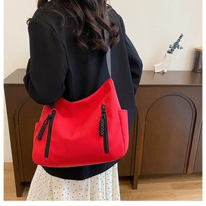 Detailed side view of a large red canvas tote bag worn by a model in a casual setting
