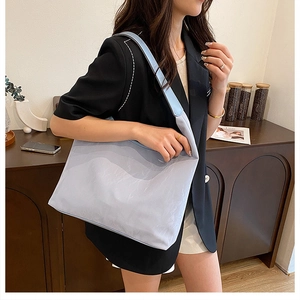 Lifestyle shot of large light purple tote bag worn over the shoulder with black blazer