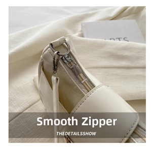 Macro shot of smooth metal zipper and premium faux leather texture on cream handbag