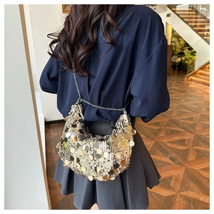 Chic gold sequin crescent evening bag with sleek metal chain strap on model