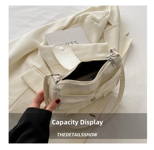 Detail view of the interior capacity of a cream bow handbag holding books