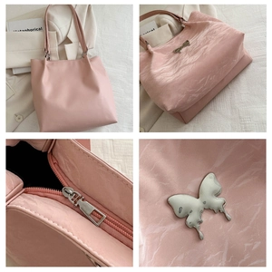 Détails du sac à bandoulière rose texturé avec papillon argenté et fermeture éclair