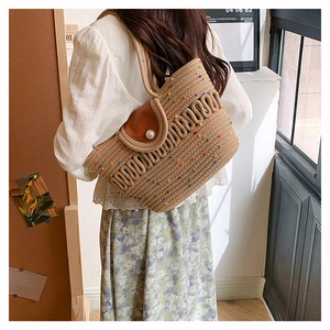 Detail of woven tote bag featuring colorful dots, leather flap and large pearl closure