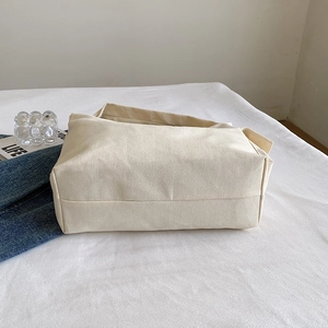 Minimalist cream canvas tote bag with large capacity shown in a clean lifestyle setting