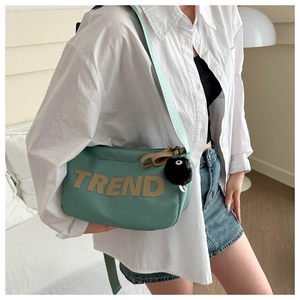 Detail view of mint green Oxford crossbody bag with TREND letter patch and wide strap