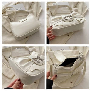Detail view of cream bow shoulder bag showing interior space and 3D bow buckle design