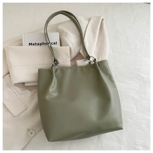 Detail of avocado green leather tote bag with elegant thin straps and metal rings