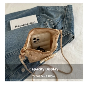 Detail showing the internal capacity of the straw woven crossbody bag with a smartphone
