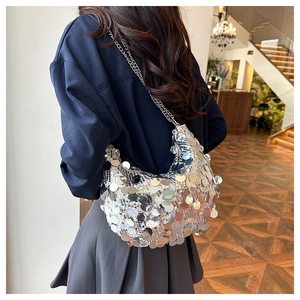 Detailed view of silver sequin crescent bag with metallic chain strap on model
