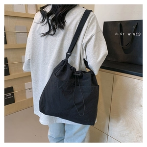 Detail of black drawstring bucket tote bag with side pocket and spacious design