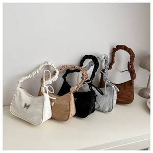 Detailed close-up of ruched texture shoulder bags with butterfly metal buckles in five colors