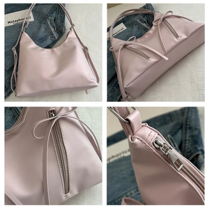 Detail view of pink tote bag showing zipper closure, ribbon bow, and soft PU texture