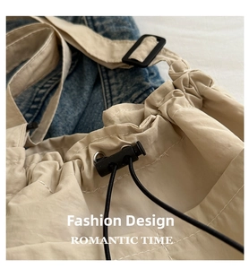Close-up of beige canvas bag drawstring closure with black buckle and metal eyelet