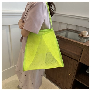Detail shot of neon green mesh tote bag with wide straps for beach and gym travel