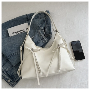 Détail du sac style ballet blanc avec fermetures éclair à nœuds sur linge de maison