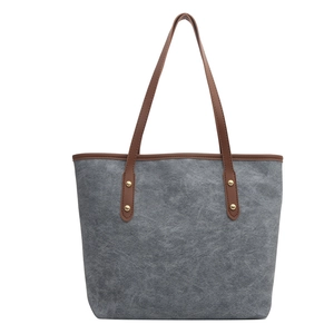 Minimalist grey tote bag with brown faux leather handles and gold rivet accents