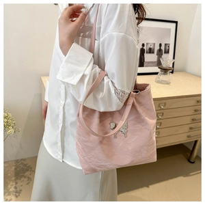 Sac fourre-tout rose avec ornement papillon et texture plissée dans un cadre chaleureux