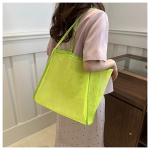 Detail of neon green mesh tote bag showing breathable texture and woven strap on shoulder