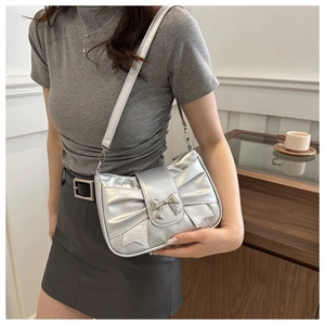Close-up of metallic silver bow handbag showing the shiny texture and detail