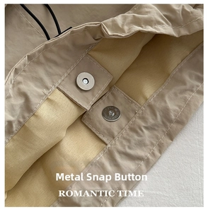 Detail of the high-quality magnetic snap closure and stitching on khaki nylon bag
