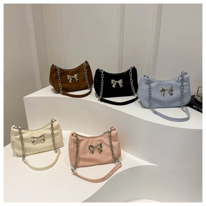 Five assorted colors of soft PU underarm bags featuring elegant metal bow decorations