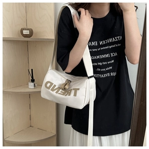 Detail of white Oxford crossbody bag showing TREND embroidery and adjustable strap