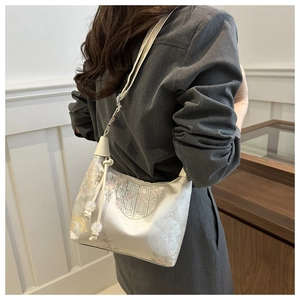 Detail of New Chinese style floral jacquard crossbody bag with tassel on woman shoulder