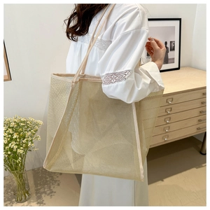 Detail of a beige mesh tote bag showing the breathable texture and durable strap design