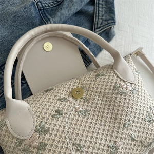 Handcrafted straw tote bag with floral embroidery and gold magnetic buckle closure